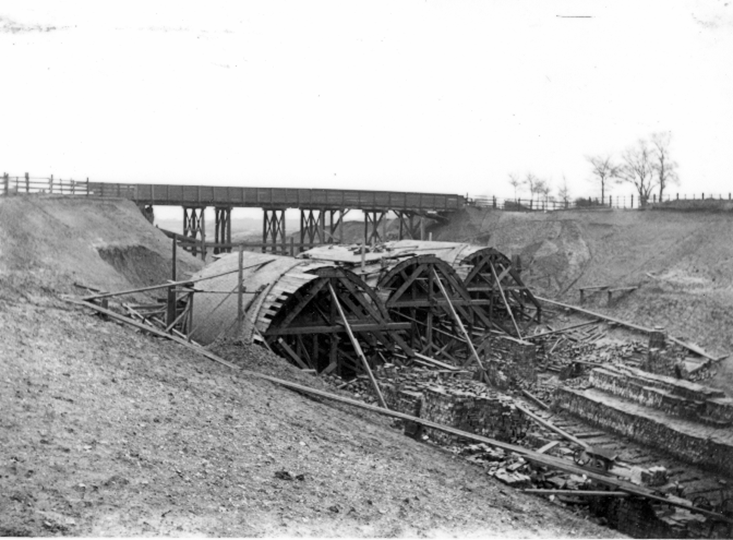 Photograph of the first ring of brick laid on a skew line over timber centring set square to the new railway beneath. To support the acute corners of the arch, centres are needed that extend beyond the masonry for most of the span.