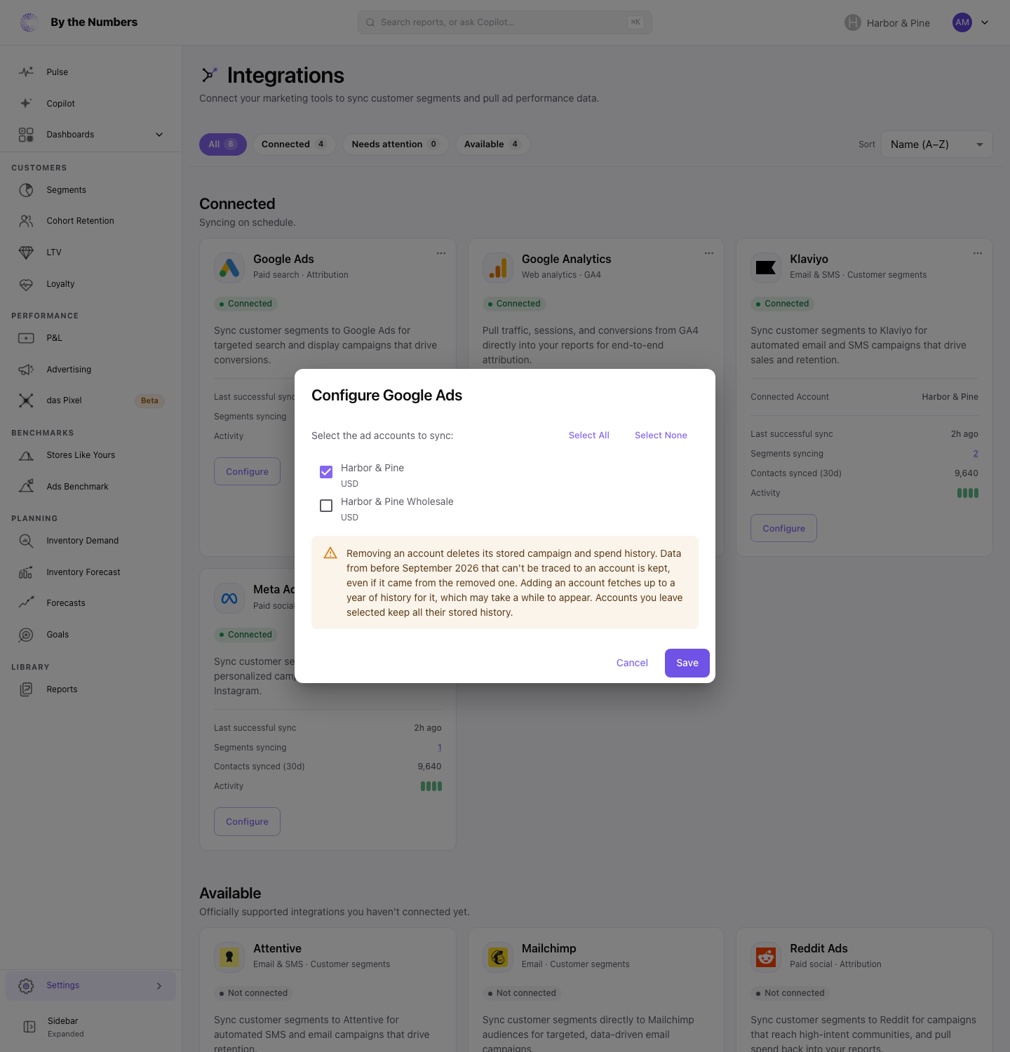 The Configure Google Ads dialog, with a checkbox for each ad account to sync, Select All and Select None, and a warning that removing an account deletes its stored history.