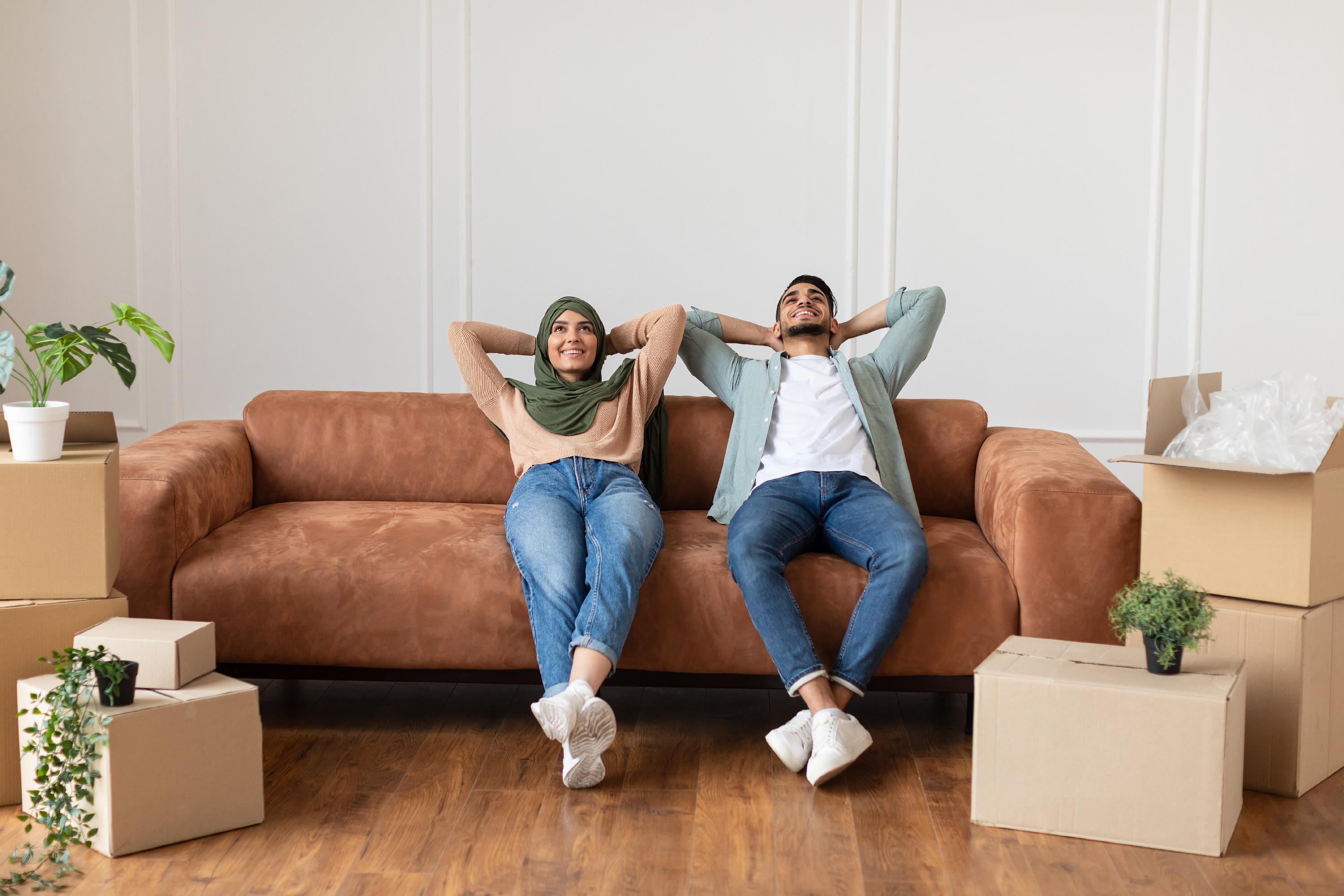 a couple relaxing on a couch, with a look of relief
