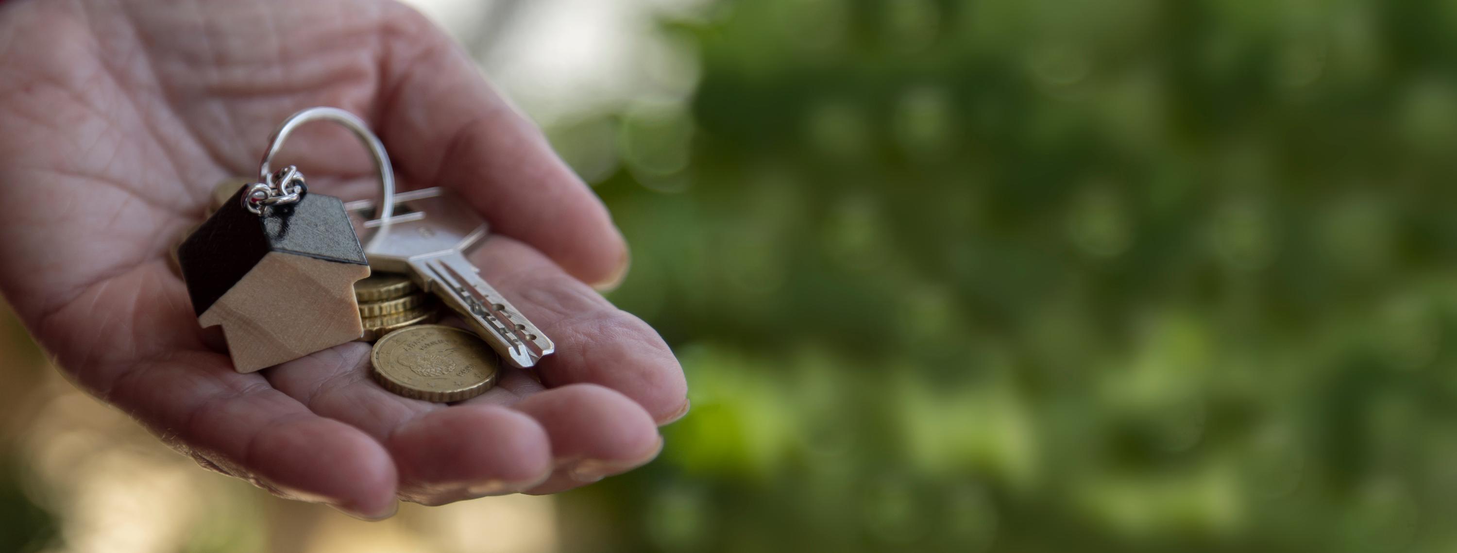 a hand holding keys and coins