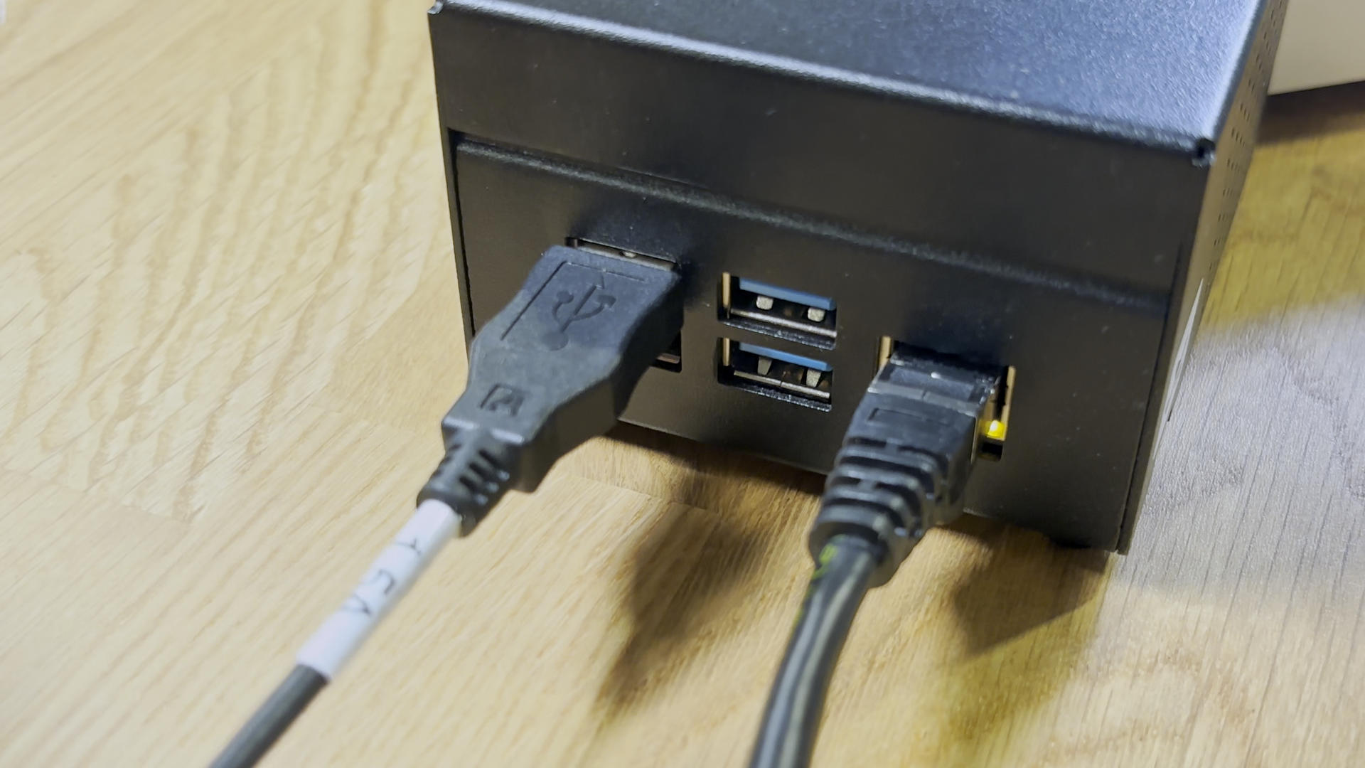 A photo of the rear of a TinyPilot Voyager 2a. A USB-A cable is connected.