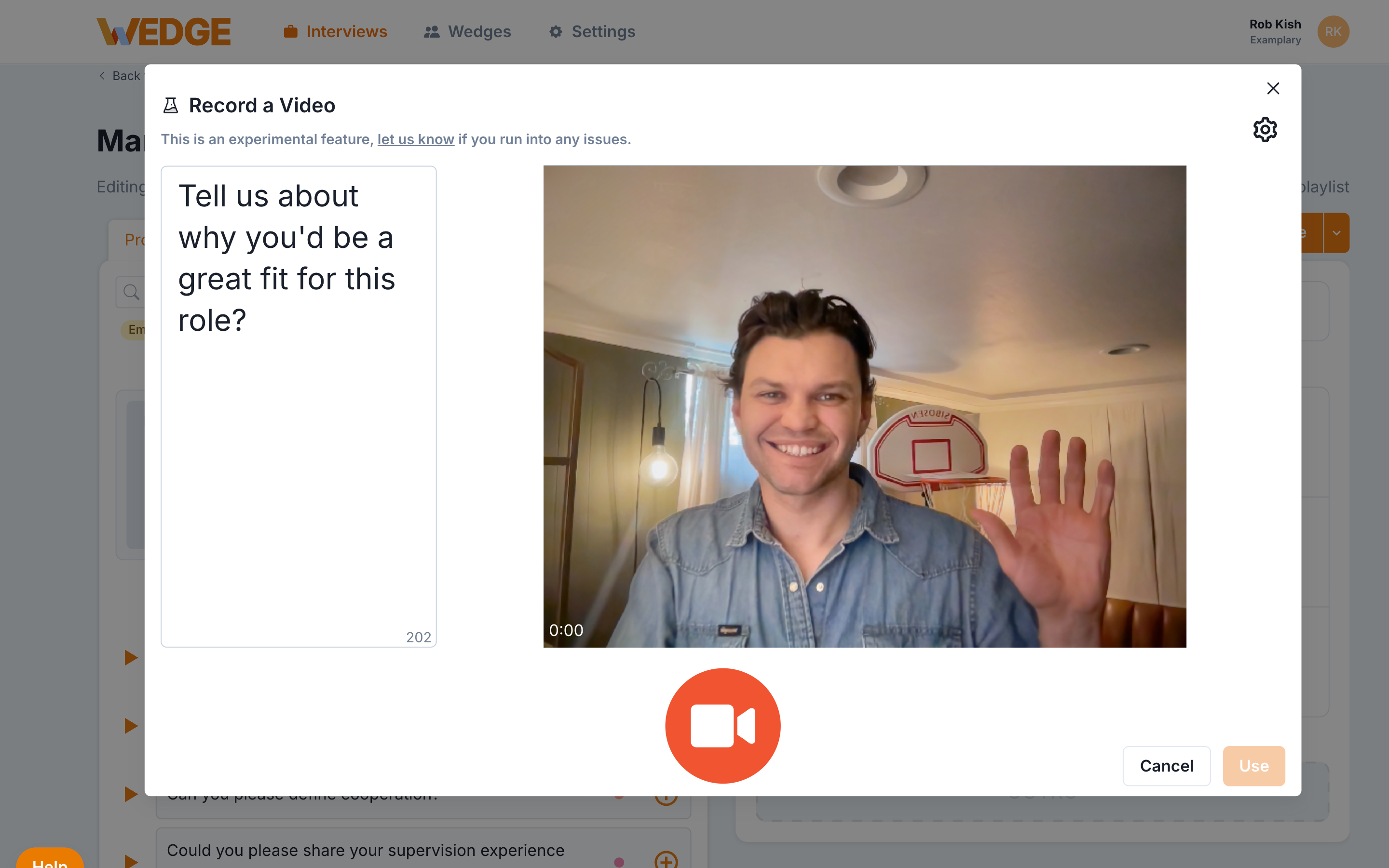 The Record a Video modal showing the prompt text on the left side and a webcam preview on the right, with an orange camera button at the bottom to start recording.