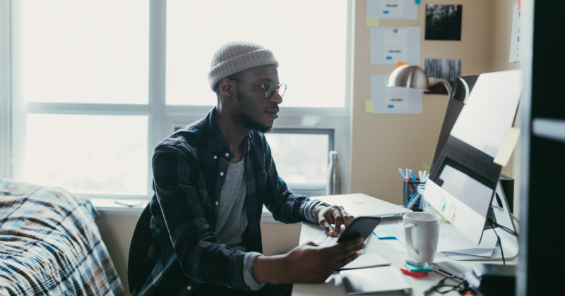 College student studying at a desk in a dorm room.