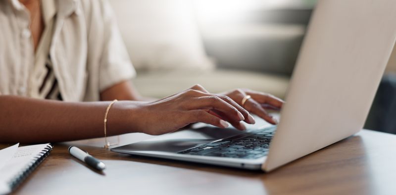 Close-up of woman typing on a laptop.
