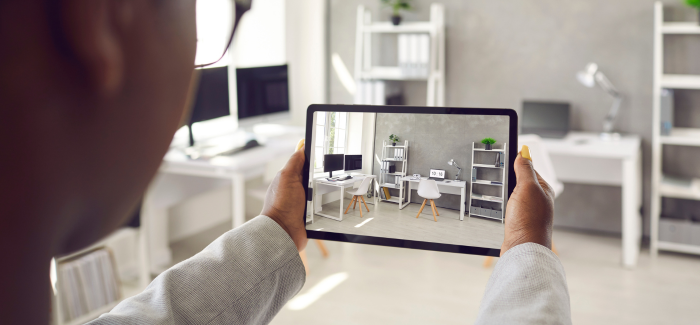 Close‑up of someone holding a tablet while recording a furnished office.