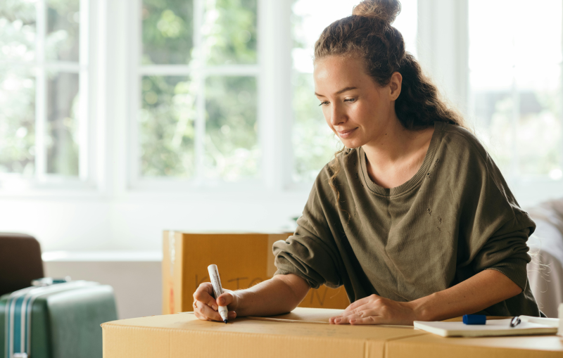 Student labeling a moving box