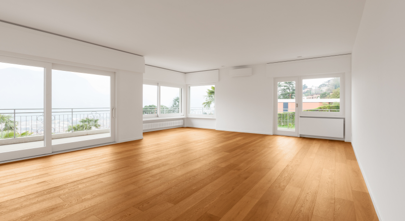 Clean, empty apartment with wood floors and white walls.