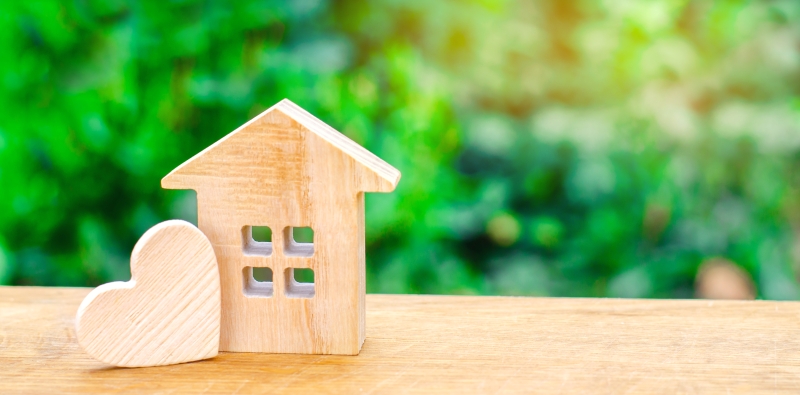 Mini wooden model of a house and a heart.