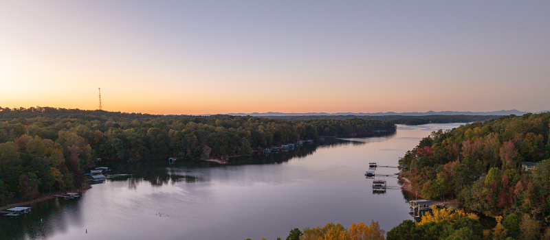 Peaceful, tree-lined river at sunset.