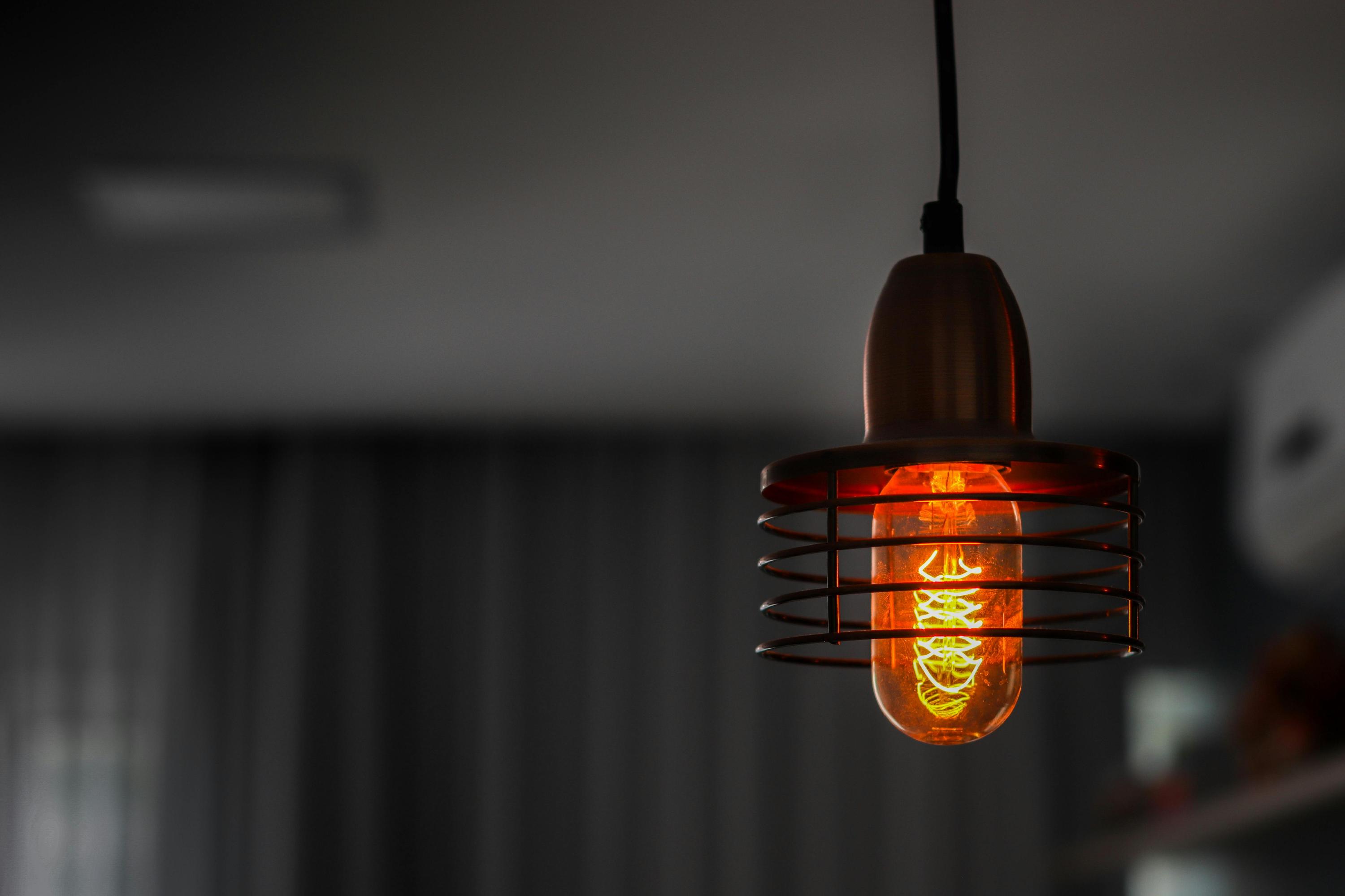 Vintage lightbulb hanging in a dark room.