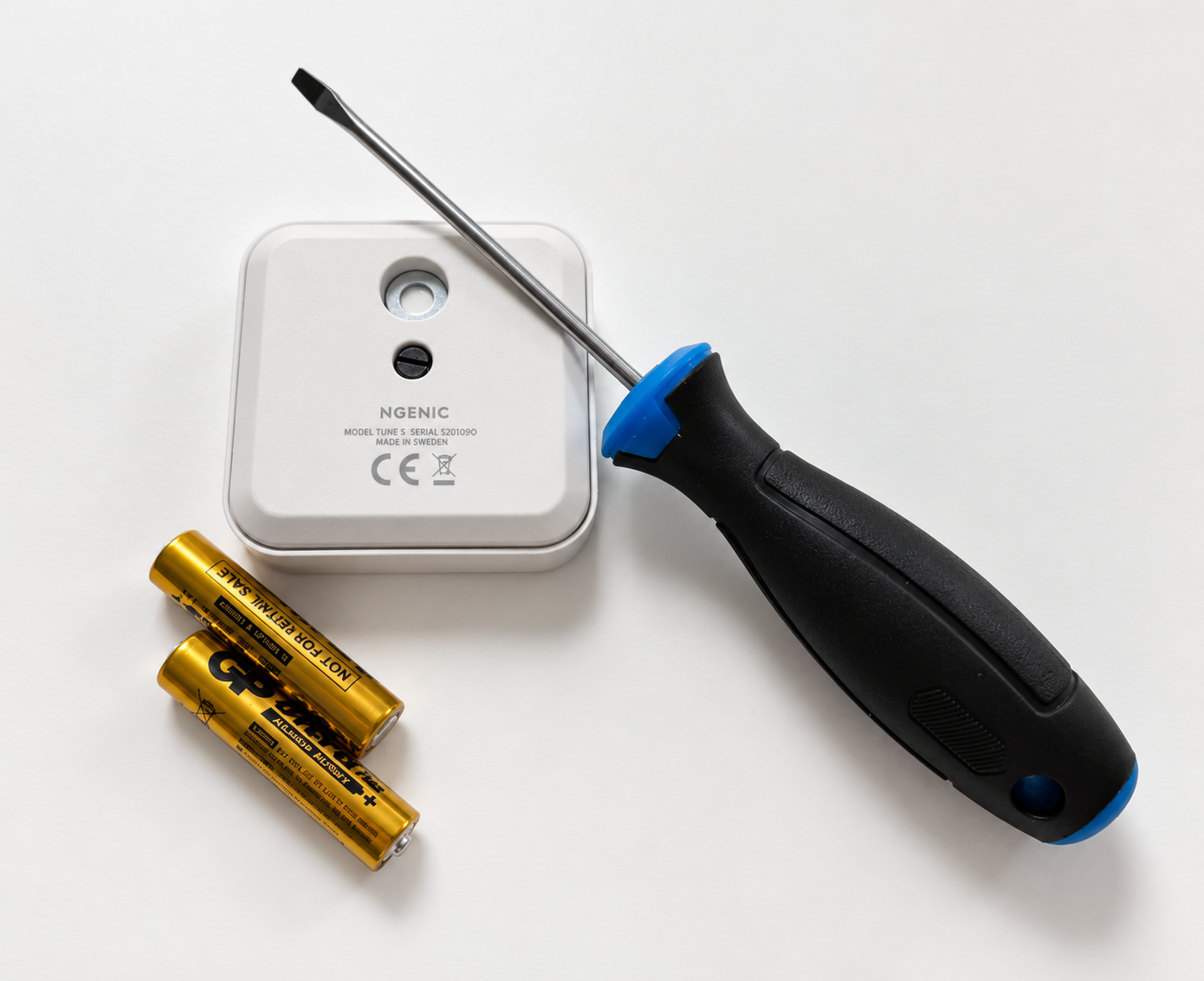 Ngenic Tune indoor sensor with two AAA batteries and a flat-head screwdriver